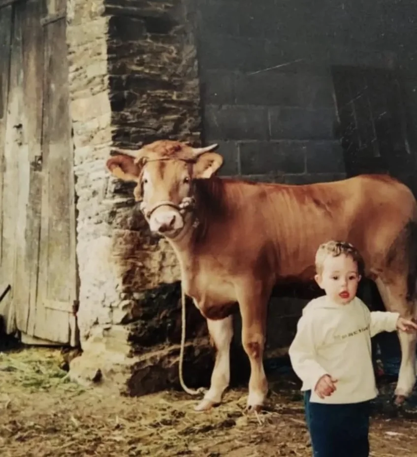 Fotografía histórica de manejo ganadero familiar junto a un bovino
